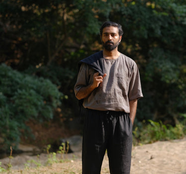 man in a grey linen T-shirt standing in a field