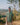 man in  Green fish hand-embroidered  linen shirt standing on a hill top overlooking a valley. Half sleeve shirt, Material: linen