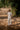 a man in a big chequered white organic cotton shirt standing in a middle of a village road. Half sleeve shirt, kala cotton fabric, suf embroidery