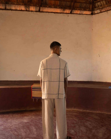 A man in eco-friendly, oh fish! hand-embroidered linen shirt in a yoga hall. half sleeves shirt, Material: linen, back view