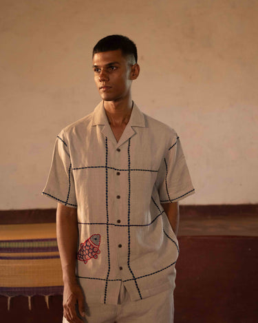 A man in eco-friendly, oh fish! hand-embroidered linen shirt in a yoga hall. half sleeves shirt, Material: linen, front view