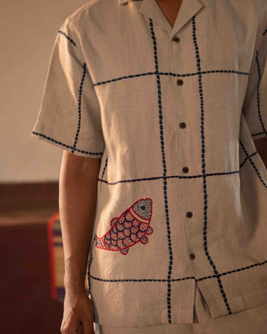 A man in eco-friendly, oh fish! hand-embroidered linen shirt in a yoga hall. half sleeves shirt, Material: linen, front view