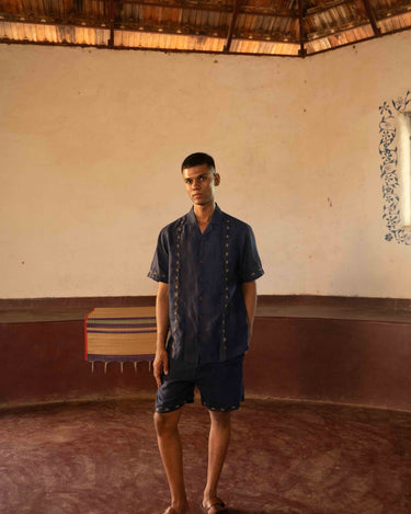 A man in eco-friendly, buds in blue hand-embroidered linen shirt in a yoga hall. half sleeves shirt, Material: linen, front view