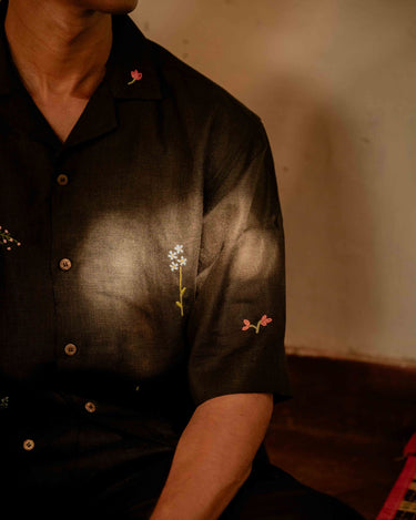 A man in eco-friendly, wild sprigs hand-embroidered linen shirt in a yoga hall. half sleeves shirt, Material: linen, front view