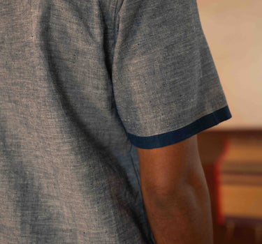 A man in eco-friendly, shades of blue patchwork cotton shirt in a yoga hall. half sleeves shirt, Material: cotton, back view