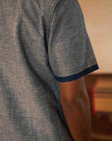 A man in eco-friendly, shades of blue patchwork cotton shirt in a yoga hall. half sleeves shirt, Material: cotton, back view