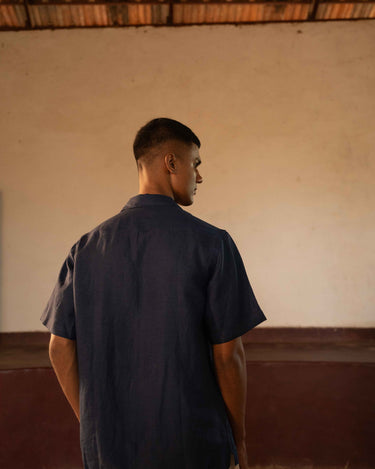 A man in eco-friendly, simple scenes linen shirt in a yoga hall. half sleeves shirt, Material: linen, back view