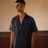 A man in eco-friendly, simple scenes linen shirt in a yoga hall. half sleeves shirt, Material: linen, front view