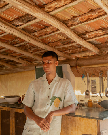 a man in the kitchen wearing green and white stripes mango embroidered linen shirt. Front view