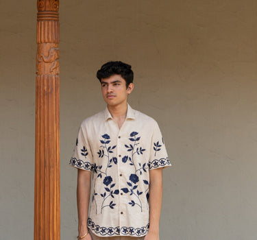 a man wearing beige linen blue floral hand embroidered shirt.