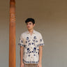 a man wearing beige linen blue floral hand embroidered shirt.