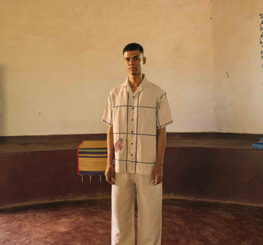 A man in eco-friendly, oh fish!  hand-embroidered linen shirt in a yoga hall. half sleeves shirt, Material: linen, front view