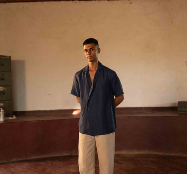 A man in eco-friendly, simple scenes linen shirt in a yoga hall. half sleeves shirt, Material: linen, front view