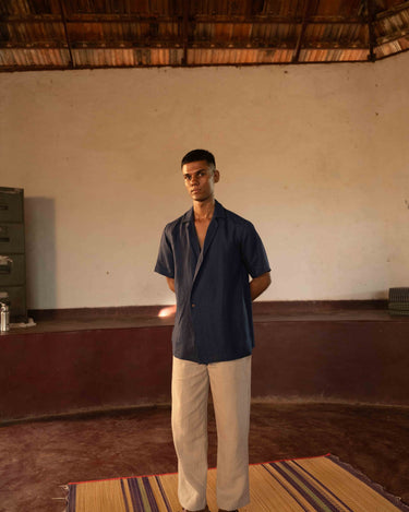 A man in eco-friendly, simple scenes linen shirt in a yoga hall. half sleeves shirt, Material: linen, front view