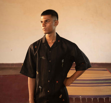 A man in eco-friendly, wild sprigs hand-embroidered linen shirt in a yoga hall. half sleeves shirt, Material: linen, front view