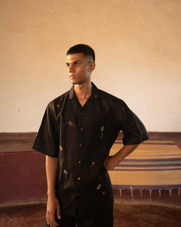 A man in eco-friendly, wild sprigs hand-embroidered linen shirt in a yoga hall. half sleeves shirt, Material: linen, front view